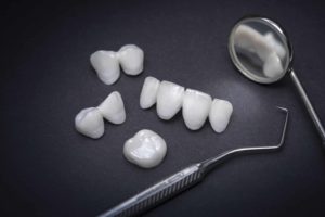 Dental tools and zircon dentures on a dark background – Ceramic veneers – lumineers
